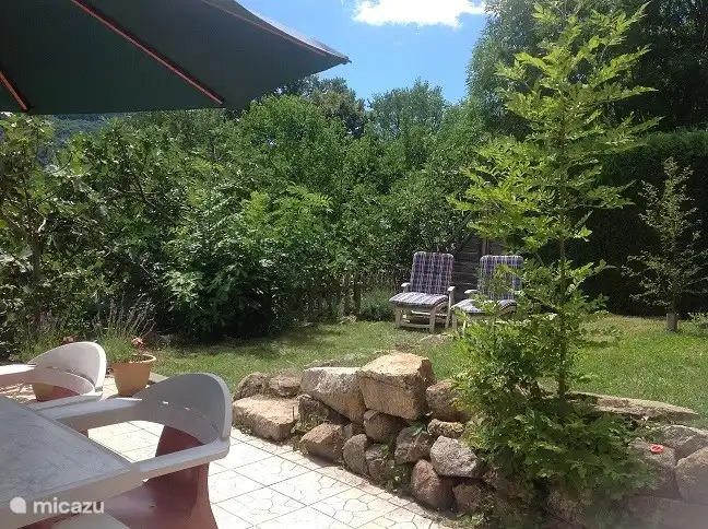 Unterer Garten, angrenzend an die Wohn-Essküche mit viel Privatsphäre, teils gefliest (25 m2), teils Rasen (25 m2) und umgeben von Hedera-Hecken, Feigenbäumen und Nadelbäumen. Mit einem Gartentor zu schließen.