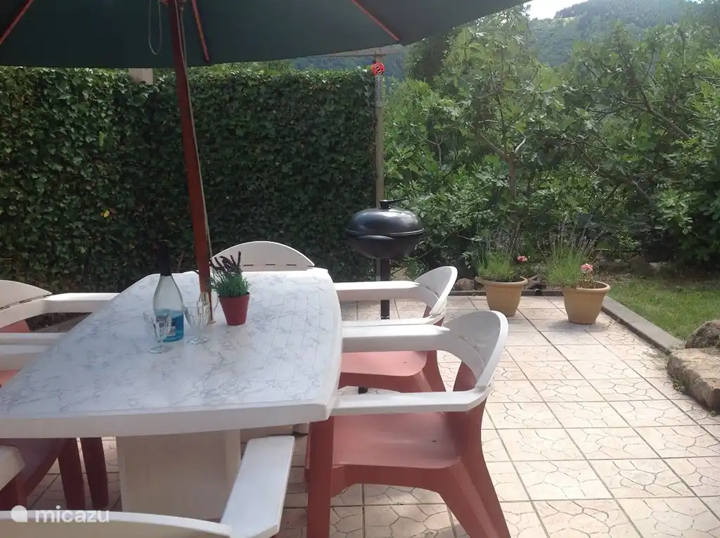 Eingezäunte Terrasse (25m2 gefliest, mit Gartenmöbeln und Sonnenschirm, 25m2 Rasenfläche, mit abschließbarem Tor, umgeben von viel Grün, Hedera-Hecke, Feigenbäumen und Nadelbäumen. Ausgestattet mit elektrischem Grill.