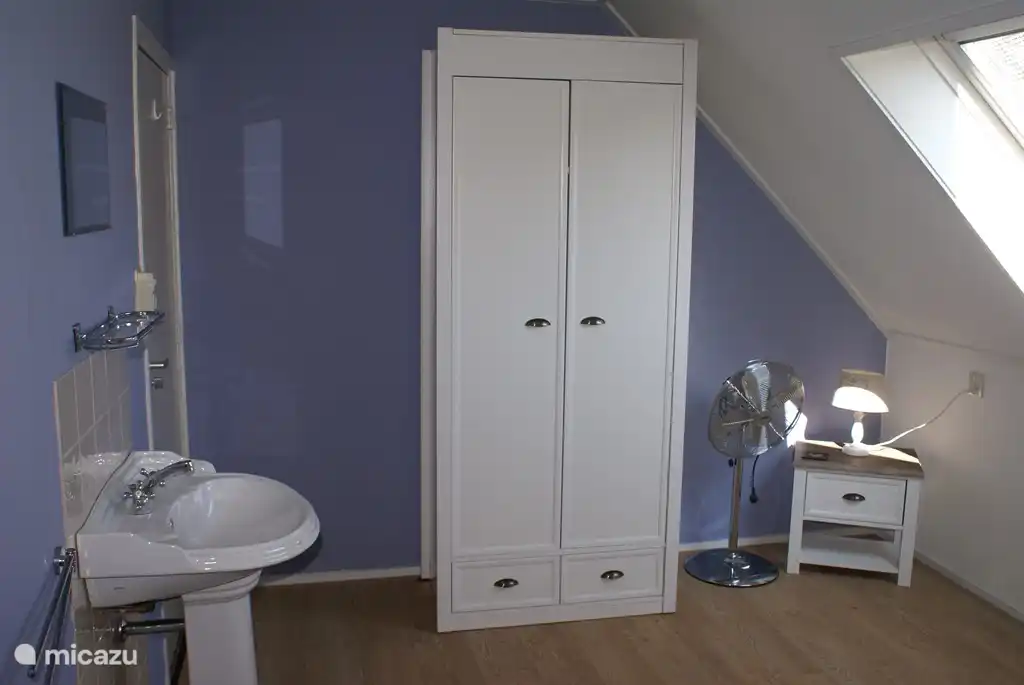 Eines der Schlafzimmer mit Waschbecken und Kleiderschrank