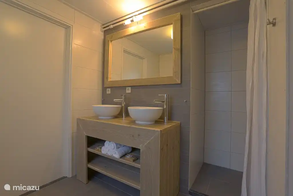 Badezimmer mit 2 Waschbecken, 1 Dusche und WC.