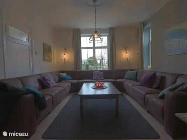 El Looische Hoeve en Países Bajos, Limburgo, Wellerlooi - casa de campo un sofá grande y acogedor para todos. Vista al jardín.