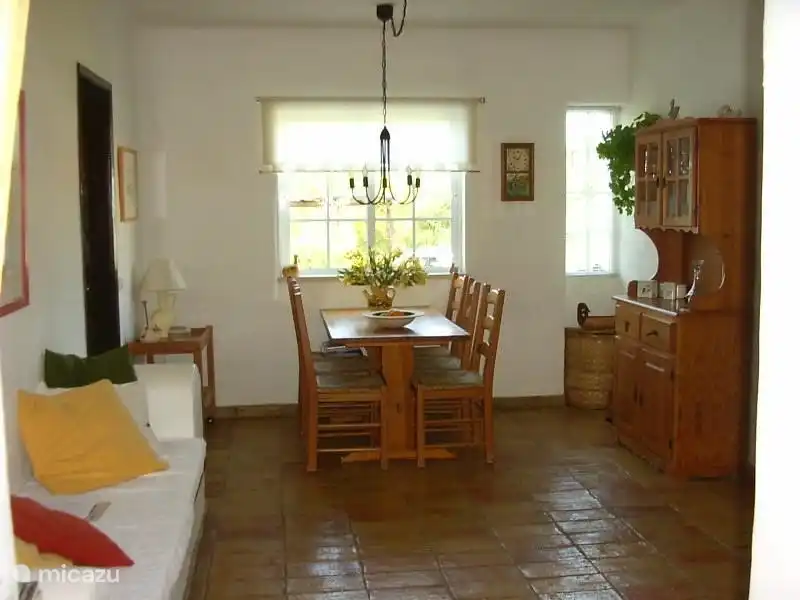 Der Essbereich mit Blick auf den Vorgarten. Links im Bild ein zusätzliches Sofa mit Kissen.