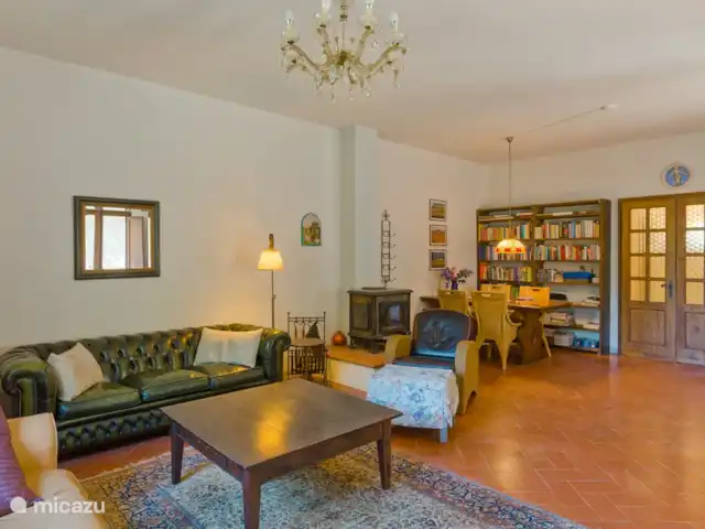 Cas'al Verde huren in Italië, Toscane, Castellina In Chianti - villa Woonkamer met eettafel, speksteen kachel en bibliotheek met o.a. boeken over de omgeving en Italië.