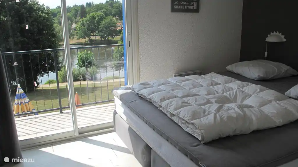 De ouderslaapkamer grenst aan het balkon, met fraai uitzicht over het meer.