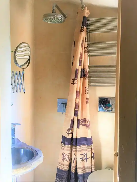 Elegante baño pequeño (1,5m2) con gran ducha efecto lluvia y mosaico de mármol bajo ducha, baldosas de gres, aseo de diseño, gran ventana para ventilar al jardín, termo de agua caliente