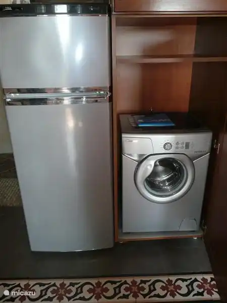 Cocina de nogal con lavadora compacta, frigorífico/congelador.