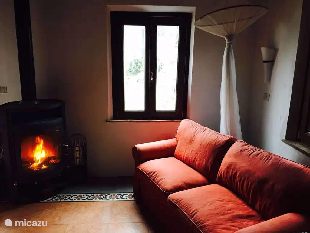 Estufa de leña, sofá cama adicional (140 cm de ancho), ventanas con vista al atardecer y al jardín, mesa de nogal (extensible) con sillas de tela de diseño, equipo de música, amplia biblioteca en 4 idiomas con novelas, libros turísticos, sofá que invita a soñar lejos, vista a 2 lados al jardín y puesta de sol
