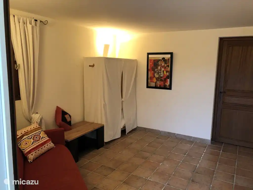 Beneden door bruine deur dan door naar keukentje en douche ruimte