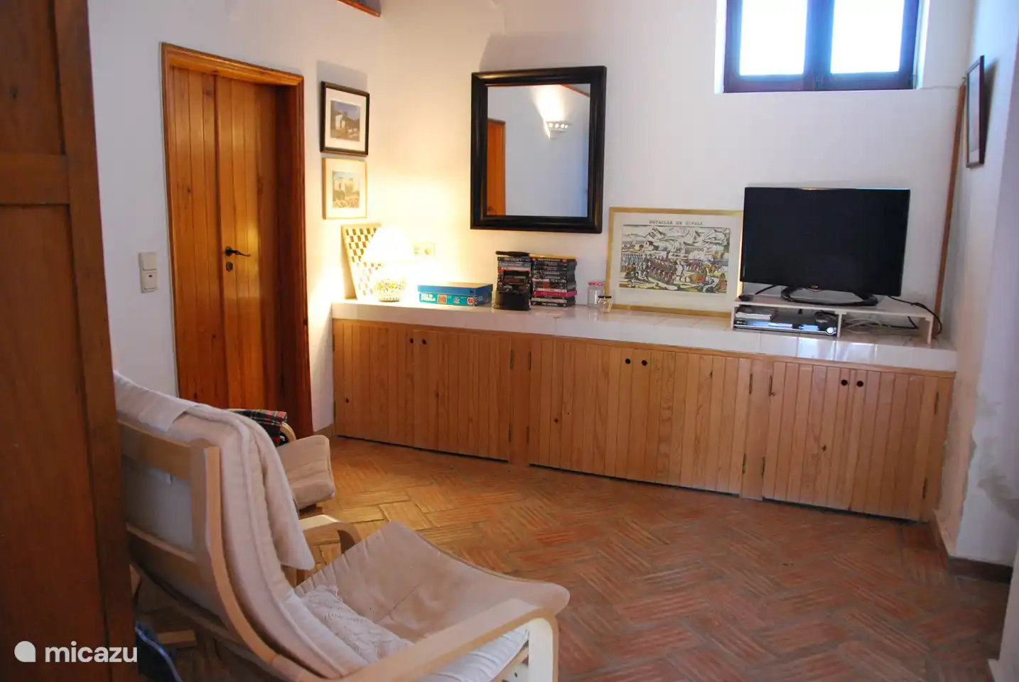 La sala de televisión con la puerta del baño a la izquierda. También hay un reproductor de DVD y varios DVD.