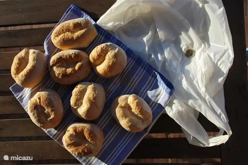 Panecillos recién hechos. Cuelga una bolsa de plástico con un euro en la farola de la carretera asfaltada a 200 metros de la casa y a la mañana siguiente el panadero la habrá llenado con cinco deliciosos panecillos portugueses.