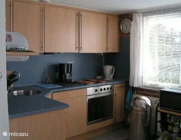 The open kitchen is fully equipped including a microwave and separate large oven and four ring hob with extractor fan, kettle and coffeemaker.