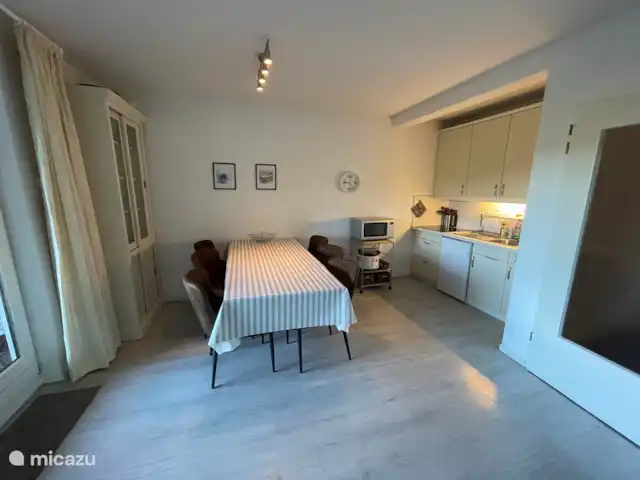 Maison Bergzicht | Allemagne, Sauerland, Willingen - appartement Le coin repas avec cuisine, avec plaque à induction, une table avec 6 chaises et un vaisselier. Sur la photo, la table est allongée d'un côté, mais elle peut également être allongée de l'autre côté.