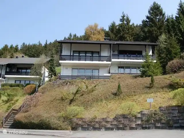 Maison Bergzicht | Allemagne, Sauerland, Willingen - appartement L'appartement (en haut à droite) vu du côté rue. Du côté de la rue se trouve une place de parking pour votre voiture et via les escaliers sur le côté gauche de la photo, vous montez jusqu'à la porte d'entrée de l'appartement.