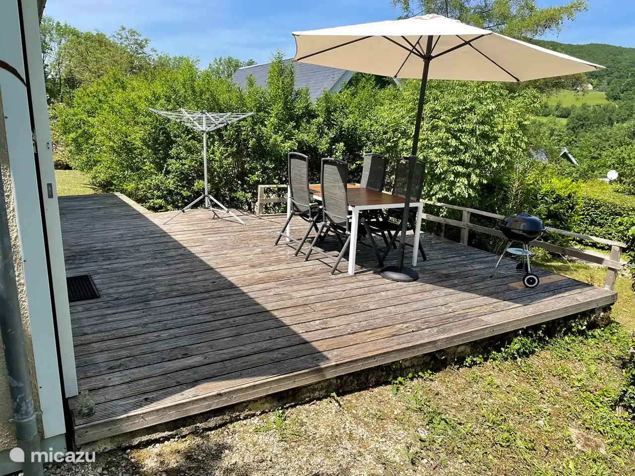 Die Terrasse ist mit Gartenmöbeln, Sonnenschirm, Grill und Wäschespinne ausgestattet.