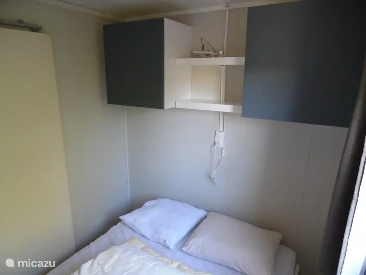 In Schlafzimmer 1 gibt es viele Aufbewahrungsmöglichkeiten durch 2 Hängeschränke und 2 Regale.