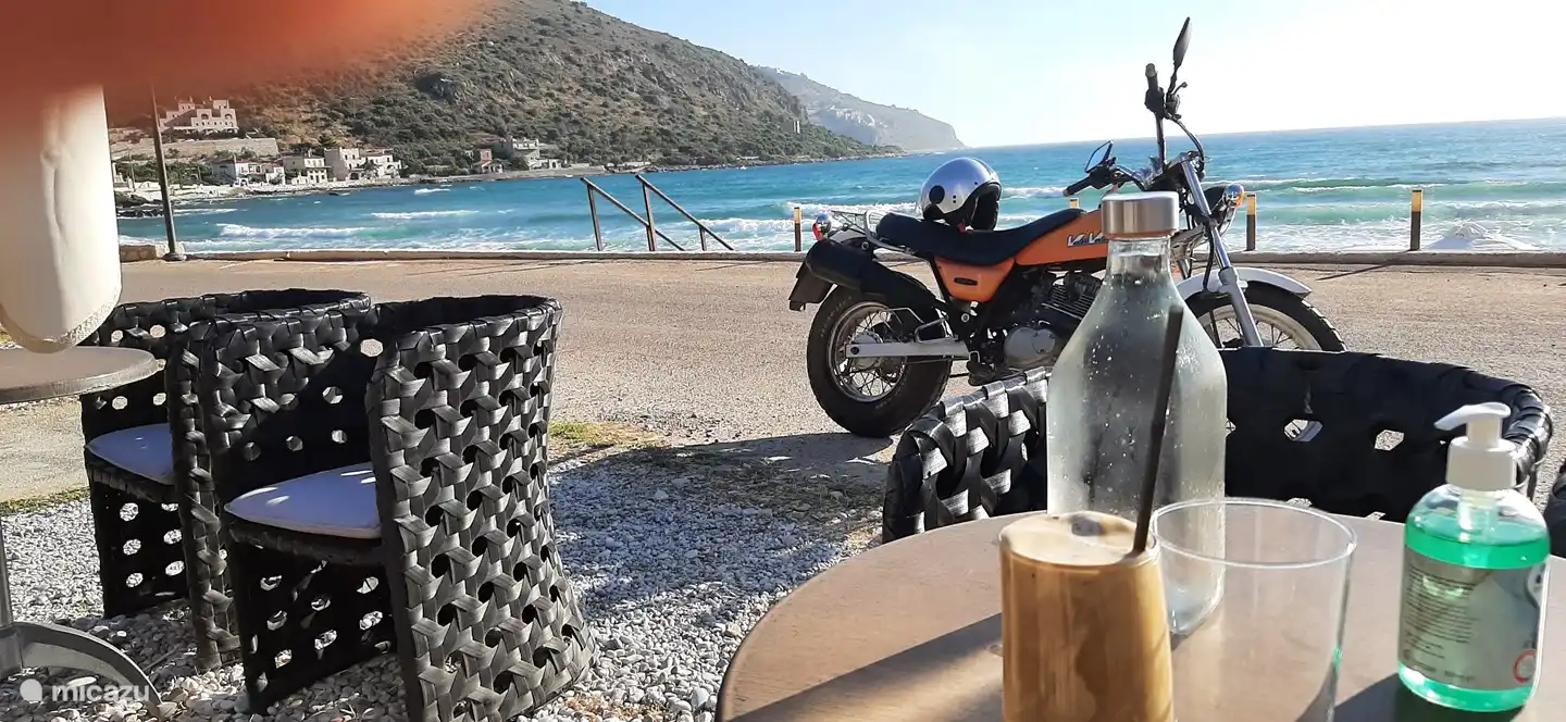 The beach and terraces of Neo Itilo. Nice by the sea with a Frappé.