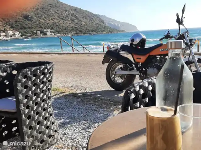 Paradisi Edo en Grecia, Peloponeso, Germa - casa vacacional La playa y terrazas de Neo Itilo. Agradable junto al mar con un Frappé.