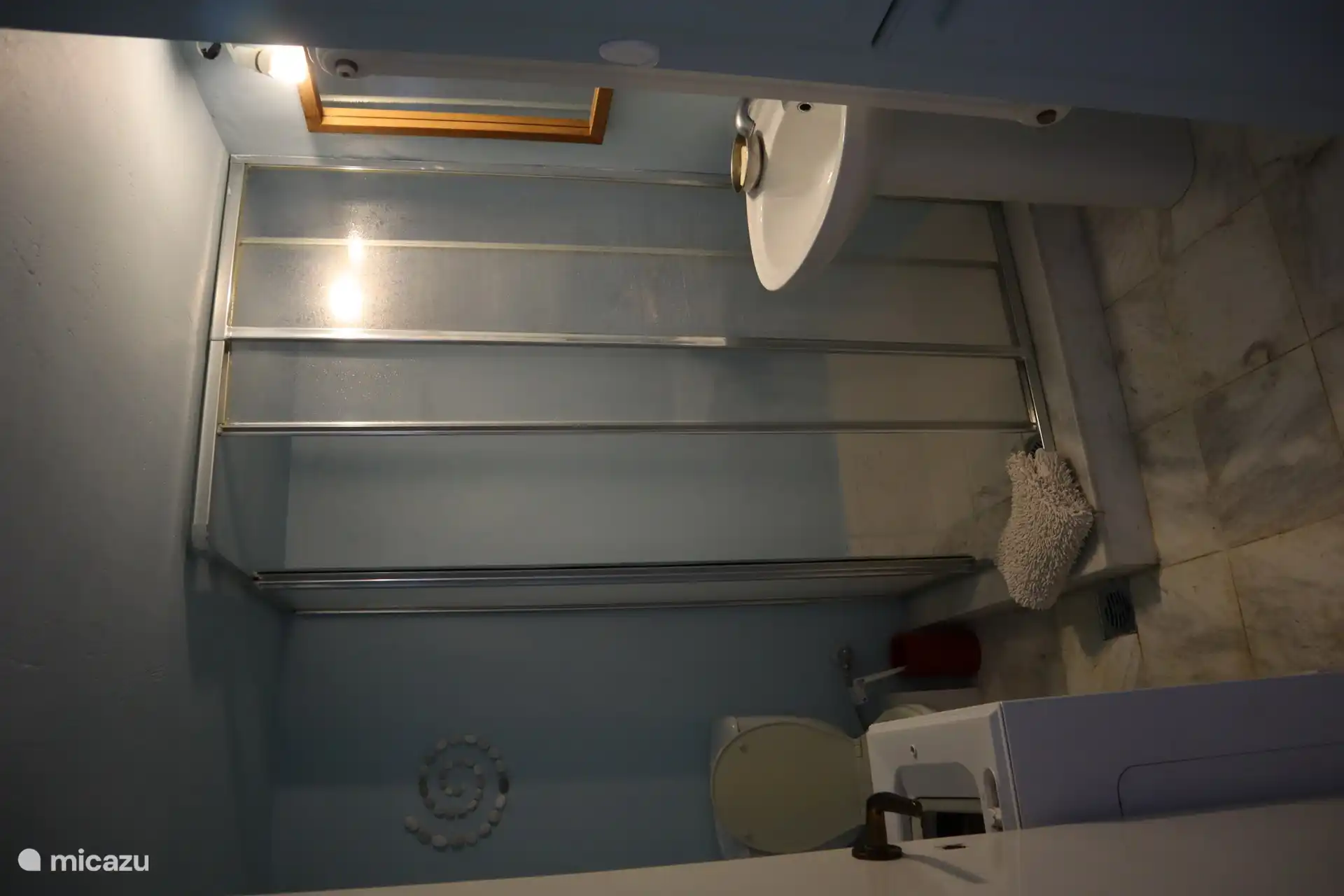 Bathroom with shower & toilet and washing machine.