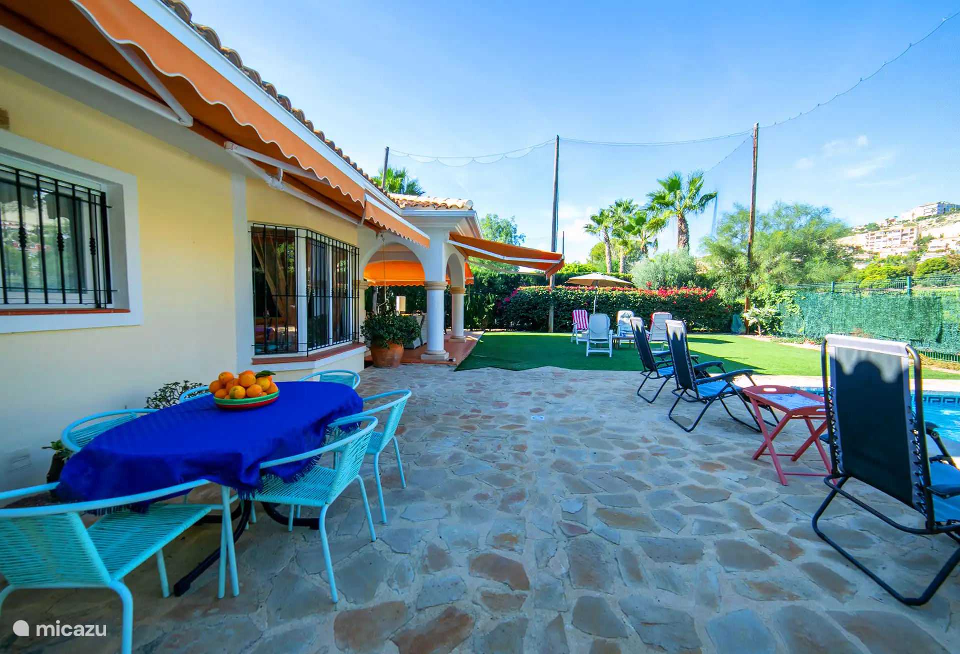 Terrasse au bord de la piscine avec table à manger dans le jardin
