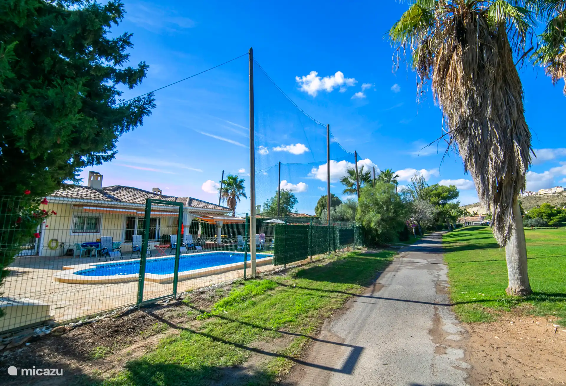 Vue de la maison et de la piscine depuis le parcours de golf