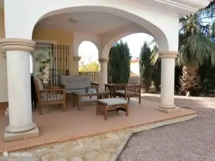 Sitzen auf der überdachten Terrasse.
Sitzecke, Esstisch und Grill.