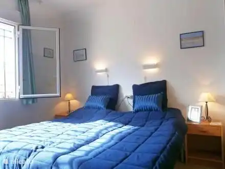 Eines der Schlafzimmer mit 2 1-Personen-Betten, Nachttische, Einbauschrank und Fensterläden.
Aircon ganzen Schlafzimmerboden.