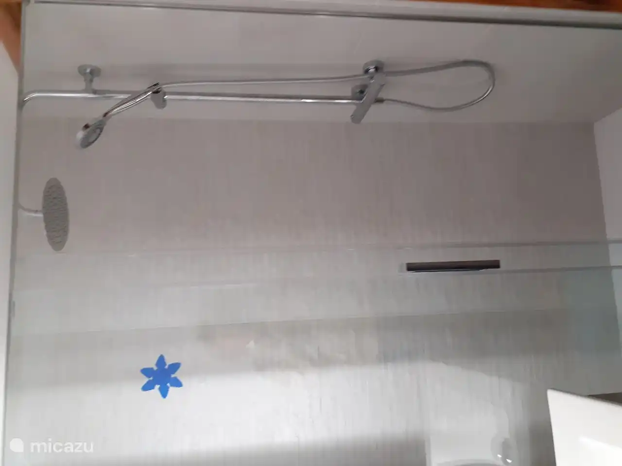 1. Badezimmer mit ebenerdiger Dusche, Waschbecken und Toilette.