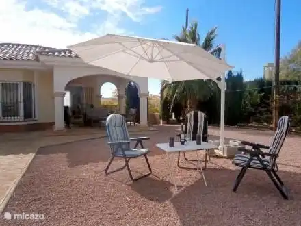 Liste Oelen, Liegestühle, Tische und Sonnenschirme am Pool.