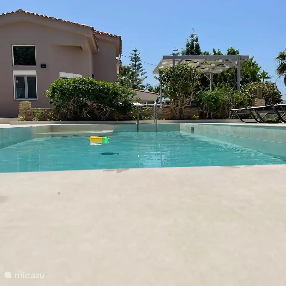 Swimmingpool mit Blick auf das Haus und Terrasse mit Pergola