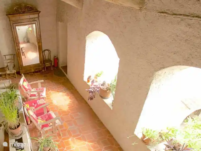 Location de Vacances France, Gard, Robiac-Rochessadoule, manoir / château - Het Elysium 4 à 5 p La terrasse couverte avec fauteuils et vue sur la cour jusqu'aux collines.