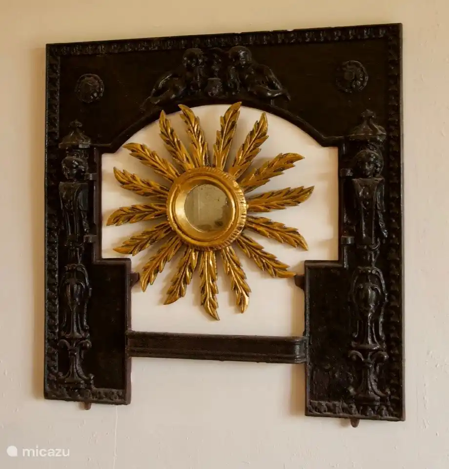 Die Sonne in einer antiken Ofentür.