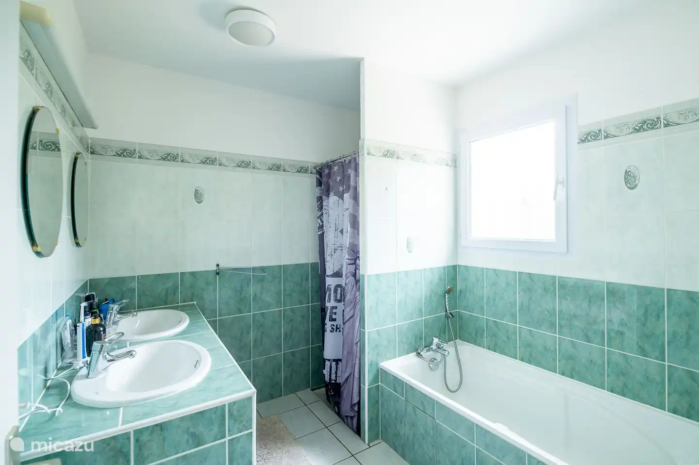 Badkamer met dubbele wastafel, douchcabine en ligbad