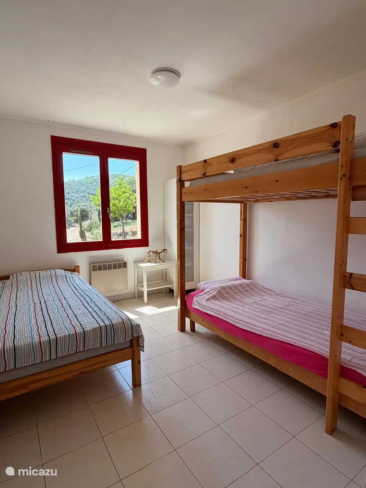 Kinderslaapkamer met een enkelbed en stapelbed.