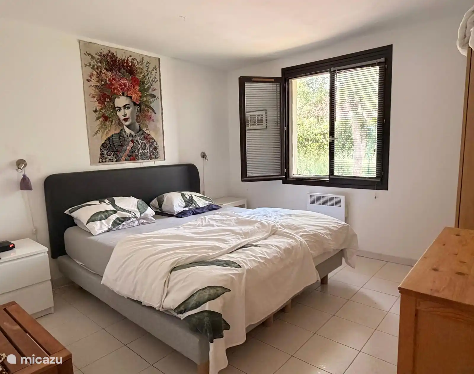 Grote slaapkamer met tweepersoonsboxspring en kleerkast.