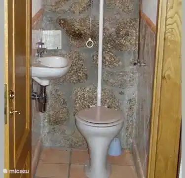 The second toilet on the first floor near the living room and two bunk bedrooms.