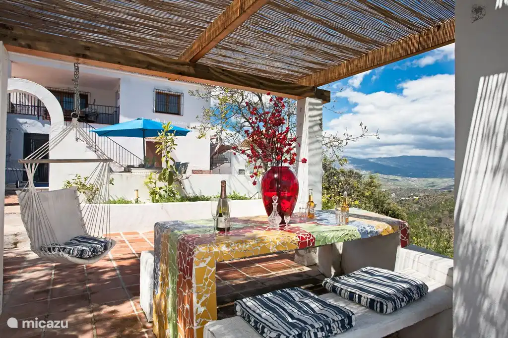 Das Haus aus dem Garten / Terrasse gesehen. Mit Links zu den Außenküche mit Grill und Spüle mit Wasserhahn. Rechts das große Mosaik Tisch mit fester Bänken.