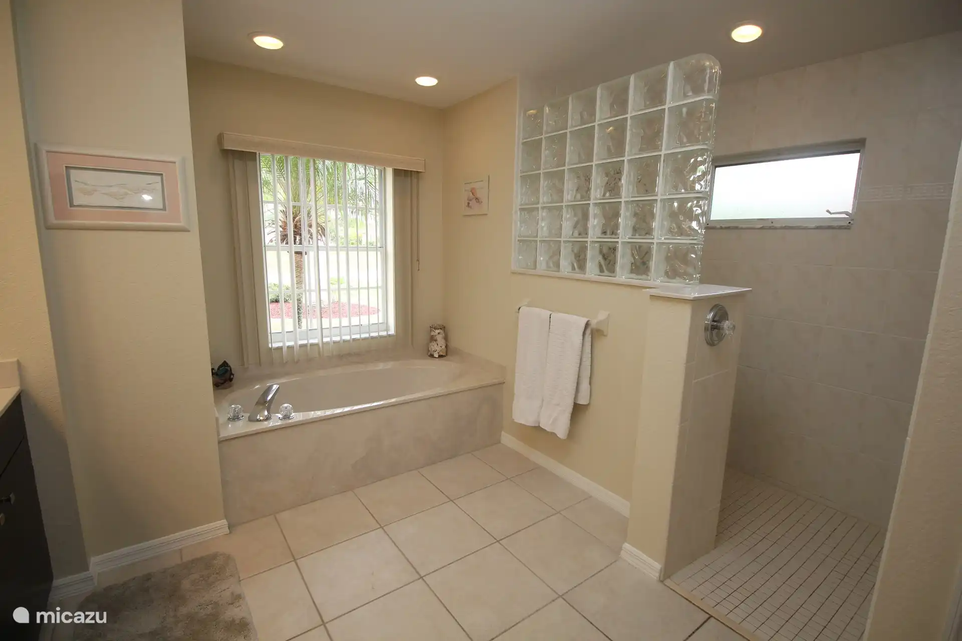 La salle de bain principale avec une baignoire spacieuse et une grande douche à l’italienne