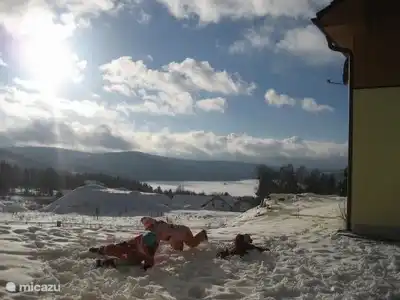 Kinder, die Spaß im Schnee neben der Hütte: Blick auf den schönen See Lipno.