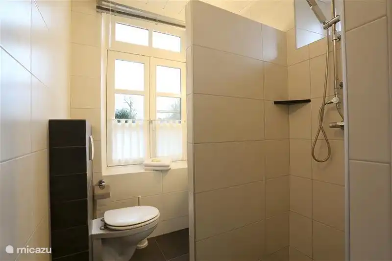 Badezimmer mit 2 Duschen, Waschbecken und WC