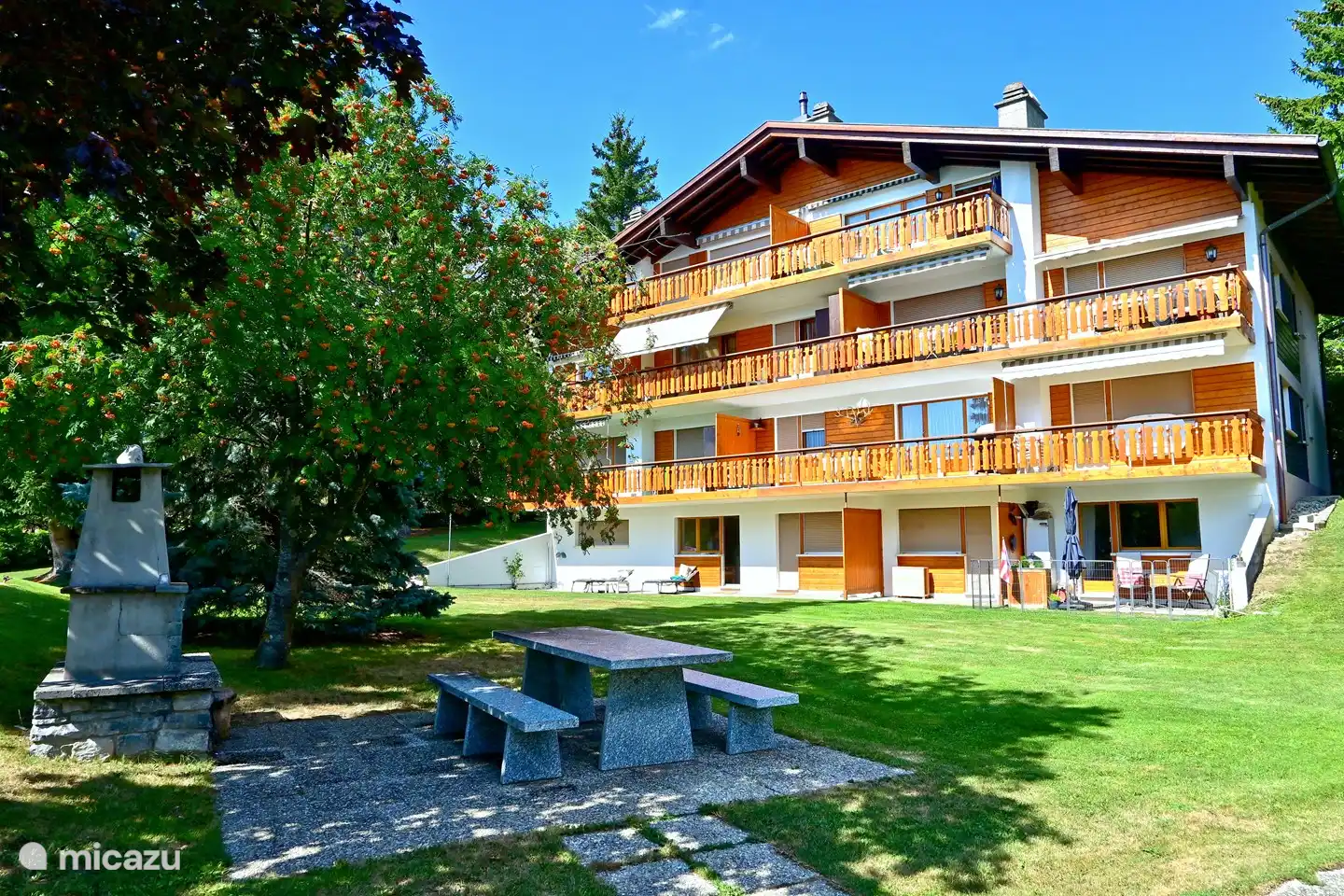 Een groot grasveld en een barbecue horen bij het huis.