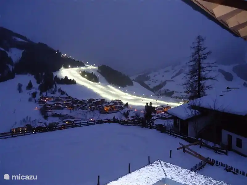 Uitzicht vanuit het Appartement op de verlichte skipiste.