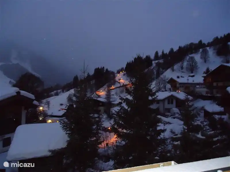 Verlichte Rodelbaan gezien vanuit het keukenraam.