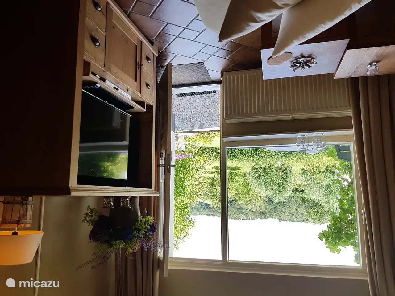 Das Wohnzimmer mit Ecksofa und Fernsehschrank von der Küche aus gesehen. Vom Wohnzimmer aus gelangen Sie auf Ihre eigene private Terrasse.