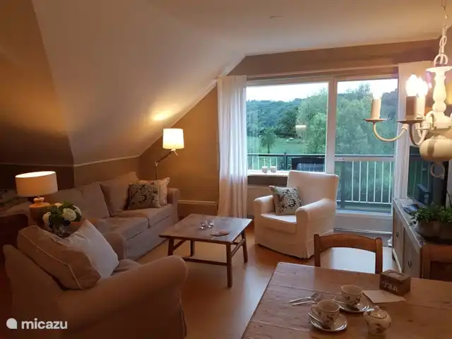 Buitenverblijf `t Herfse - 3 | Pays-Bas, Limbourg, Malines - ferme Le salon dispose d'un canapé 2 places, de deux fauteuils et d'une télévision connectée. Depuis le coin salon et le balcon privé attenant, vous avez une vue fantastique sur les collines pittoresques du sud du Limbourg.
