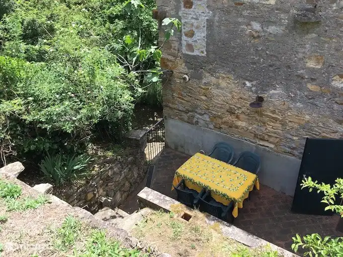 Puedes comer afuera, una mesa con sillas te espera en una terraza pavimentada.