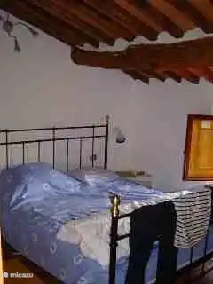 Dormitorio al frente. La construcción tradicional también se ha mantenido en los dormitorios con un precioso suelo de terracota y un techo con vigas tradicionales.