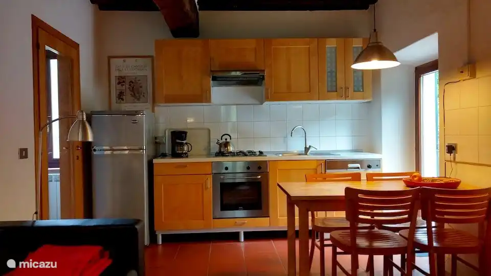 La sala de estar del anexo de la cocina está amueblada de manera ordenada y sobria. Adyacente se encuentra la terraza exterior de piedra natural y en una meseta más alta, a unos pocos escalones, se encuentra una terraza de césped donde se puede tomar el sol y disfrutar de la vista.