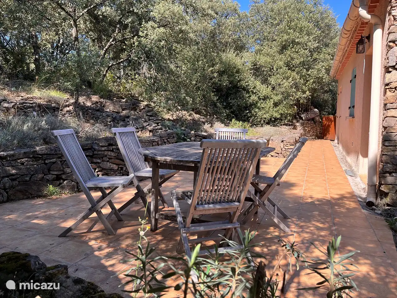 Die Terrasse des Four Seasons House grenzt an den Wald, blickt auf die Hügel und verfügt im Sommer über einen Sonnenschirm.