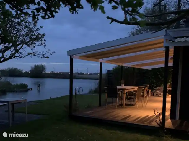 bungalow huren in Nederland, Noord-Holland, Schardam – Koggenbungalow ‘S avonds is de veranda sfeervol verlicht