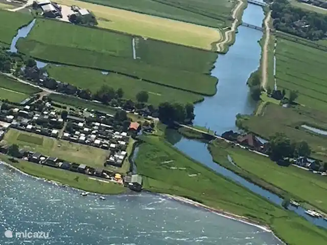 bungalow huren in Nederland, Noord-Holland, Schardam – Koggenbungalow luchtfoto, de bungalow ligt bij het brede water naast de sluisjes